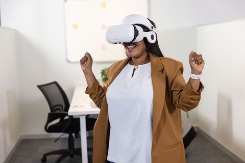 African American professional exploring VR in modern office wearing white VR headset