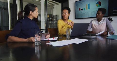 Businesswomen Analyzing Data in Corporate Meeting Room
