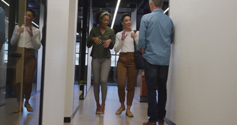 Diverse Professionals Discussing in Modern Office Hallway