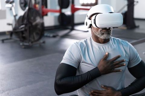 Senior african american athlete wearing vr headset doing breathwork and meditation in gym