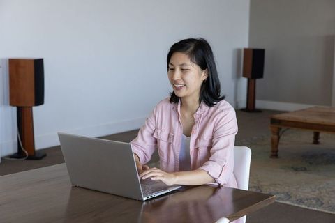 Asian woman using laptop in contemporary home office