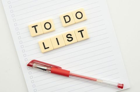 Organized to-do list with red pen and lined paper
