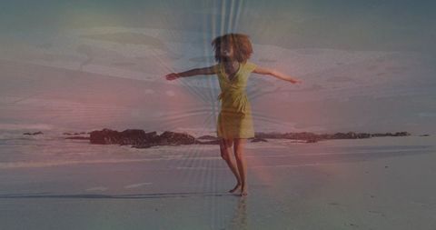 Spinning in yellow wrap dress on reflective beach with pastel lens flare