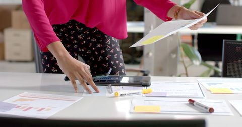 Casual businesswoman analyzing statistics at office desk