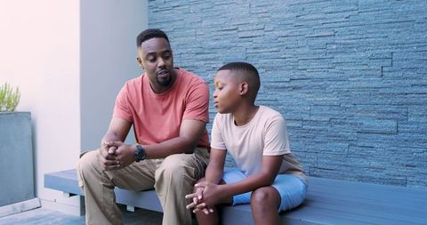 Father and Son Bonding Moment Outdoors by Stone Wall