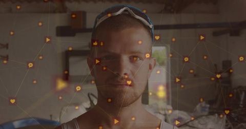 Handyman standing in workshop wearing goggles and tank top with social media network overlay