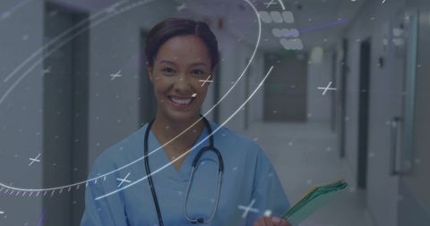 Smiling Nurse Standing in Hospital Corridor Holding Patient Folders