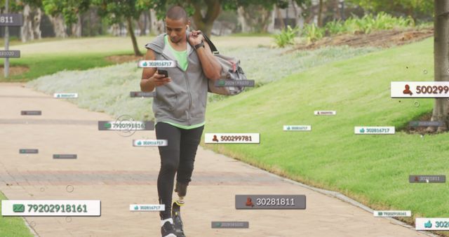 Young man engaged with multiple digital devices while walking in a serene park setting, illustrating the integration of technology into everyday life. Ideal for depicting themes of connectivity, modern communication, digital interactions, and the influence of social media.