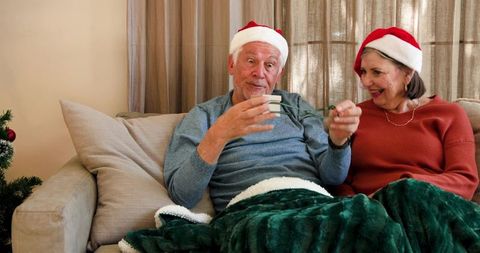 Senior couple enjoying holiday preparations with christmas lights