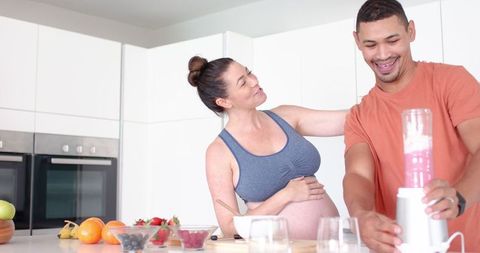 Diverse Couple Making Healthy Smoothie Together in Modern Kitchen