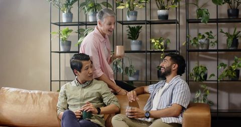 Diverse friends chatting on leather sofa in modern indoor garden