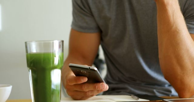 Man Drinking Green Smoothie While Using Smartphone - Download Free Stock Images Pikwizard.com