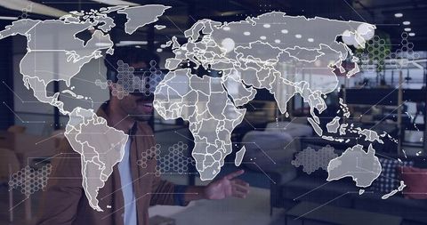 Presenting man gesturing with digital world map overlay in futuristic coworking office