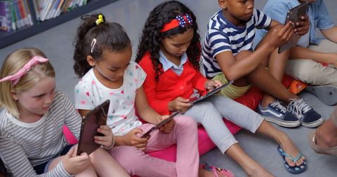 Children learning on tablets in classroom setting