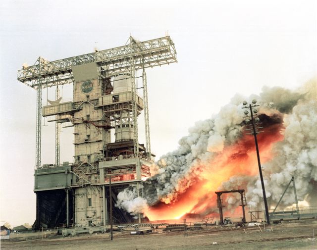 This image captures a dual position Saturn I/IB rocket test at the T-Stand at Marshall Space Flight Center during the 1960s. The stand allows for the simultaneous testing of two rockets, enabling engineers to compare identical burns. This historical scene from NASA's early space exploration efforts could be used in documentaries, educational materials, or articles related to space history, engineering, and aeronautics.