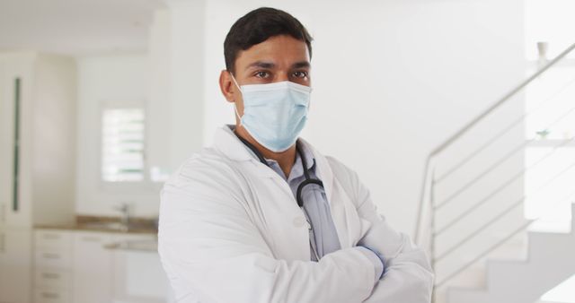 Portrait of hispanic male doctor at home, all wearing face mask. medical professional making patient home visit during coronavirus covid 19 pandemic.
