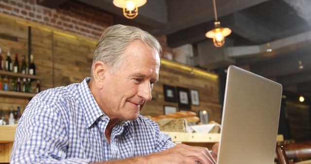 Senior Man Working on Laptop in Modern Café - Download Free Stock Images Pikwizard.com