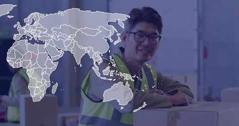 Smiling warehouse worker with world map overlay in logistics facility