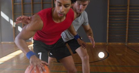 Intense one-on-one basketball game in indoor gym