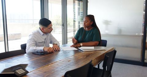 Diverse Professionals Discussing Business Contract in Modern Office