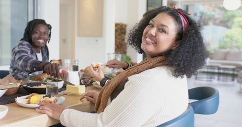Diverse Friends Enjoying Casual Home Dinner Around Wooden Table Sharing Comfort Food