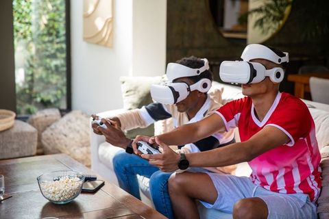 Friends using vr headsets for gaming in modern living room