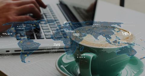 Typing on laptop with latte and global data map overlay for remote work and analytics