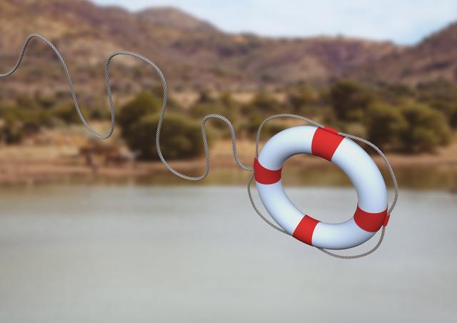 Digital composition of lifebuoy with rope against mountains in background