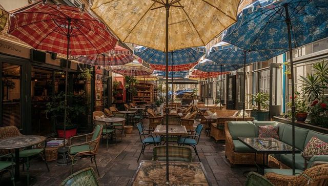 Creating cozy courtyard cafe with patchwork umbrellas, wicker seating and lush plants
