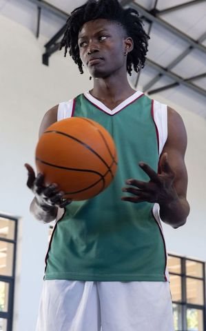 Athletic Man Holding Basketball on Indoor Court
