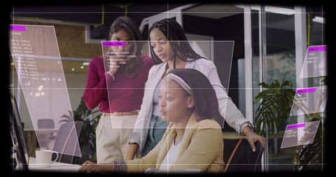 Women collaborating around laptop with augmented ui overlays in modern coworking workspace