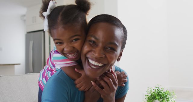 Portrait of happy african american mother and daughter hugging at home. staying at home in self isolation during quarantine lockdown.