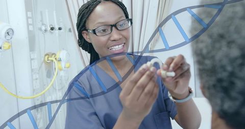 Healthcare professional assisting patient with hearing aid