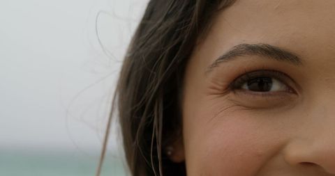 Close-up of Smiling Woman on Beach with Wind-Tousled Hair