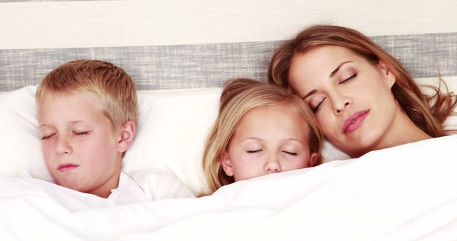Happy family sleeping together in a bed