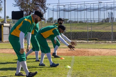 Baseball infielders practicing grounder drill with cones, team training on outdoor field