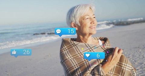 Elderly woman on beach with social media notifications symbols