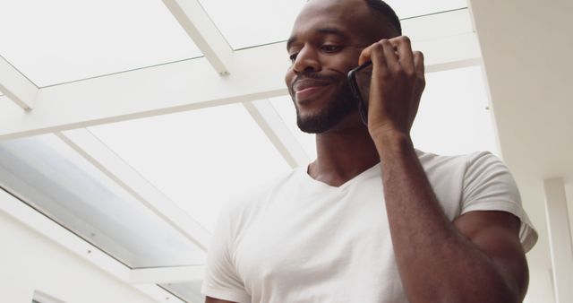 Confident Man in White T-Shirt Having Phone Conversation - Download Free Stock Images Pikwizard.com