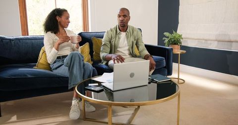 Happy Couple Discussing Achievement Together at Home with Laptop