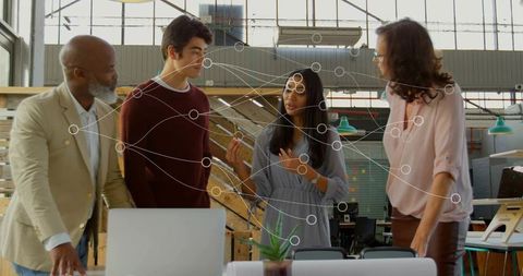 Multigenerational team collaborating on tech and design project in bright loft office with network o