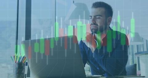 Financial analyst studying candlestick charts on laptop in daylit modern office workspace