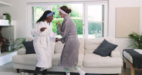 Diverse Female Friends Dancing in Cozy Living Room Setting