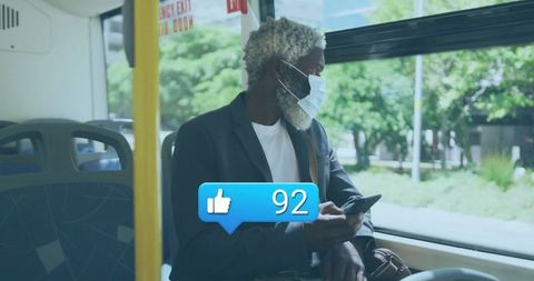 Elderly man using smartphone on bus wearing face mask