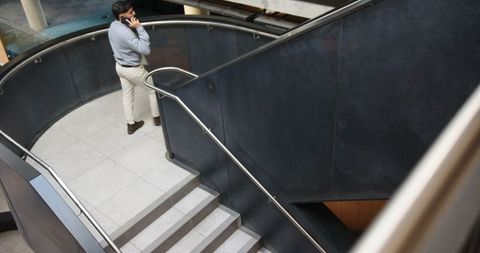 Professional Man Making Phone Call on Modern Staircase Landing