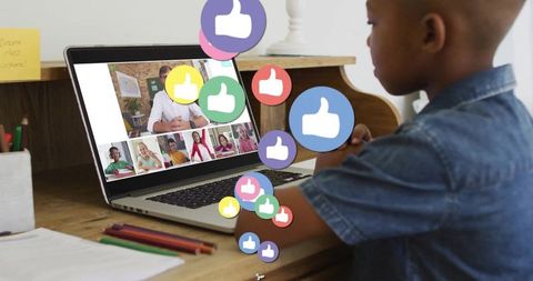 Young boy engaging online learning with thumbs up