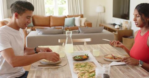 African american couple sharing relaxed homemade meal at sunlit rustic dining table
