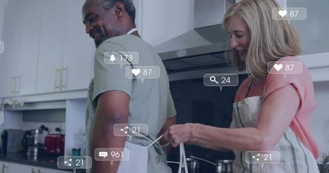 Mature couple cooking together in modern kitchen with social media overlays