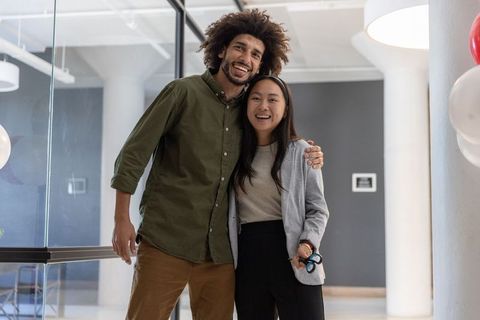 Diverse coworkers celebrate in modern office space