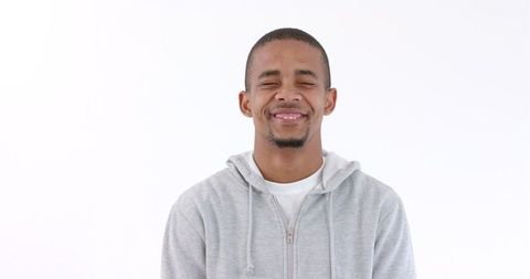 Smiling Man in Gray Hoodie Exuding Confidence and Happiness