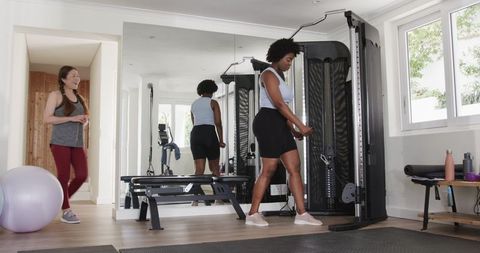 Fitness Trainer Encouraging Woman During Weight Training at Gym